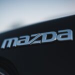 Focus on the Mazda logo on a car, showcasing sleek design and branding.